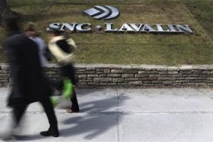 Pedestrians walk past a sign for the head office of SNC Lavalin in downtown Montreal Highway 407, West Face Capital
