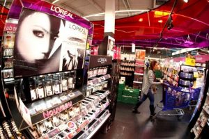 A customer walks past a cosmetics display of French cosmetics group L'Oreal in Nice
