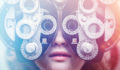 A woman's eyes are tested using a Photopter , determining whether she is due for an update in glasses prescription. Could also depict an ophthalmologist. Colorful lights add a futuristic feel to the image.