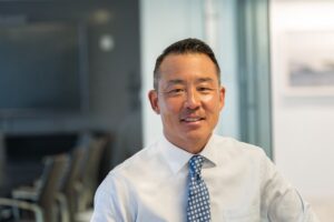 Charlesbank CEO Michael Choe wearing a blue tie and white shirt