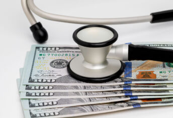 Healthcare cost containment services find PE buyers: 5 deals Photo of a stethoscope and cash money, representing concepts of the healthcare, health insurance and medical bills.