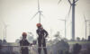 Blue collar in focus: HIGโs industrial and infrastructure maintenance group Coriant makes add-on; Mutares sells part of crane manufacturer F.lli Ferrari Close up professional wind turbine maintenance team wearing PPE and Safety harness walk working in Wind turbine farm, Green and Renewable Energy concept