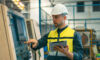 Worker and engineer using tablet computer for inspection and checking production process on factory station.