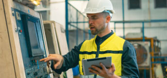 Worker and engineer using tablet computer for inspection and checking production process on factory station.