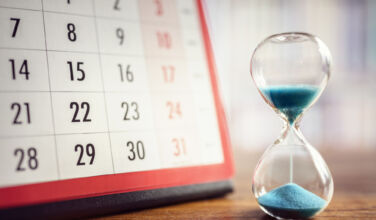 Hour glass and calendar concept for time slipping away for important appointment date, schedule and deadline