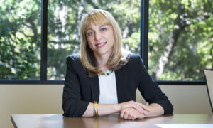 Andrea Auerbach of Cambridge Associates sitting at a table with trees in background