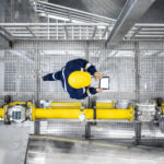 Top view of refinery worker walking by gas pipes, checking gasoline supply and installations in production plant.