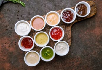 Picture of dipping sauces and condiments on a rustic background.