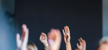 Engaged Audience Raising Hands at Business Event