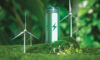 Photo of a green eco-battery surrounded by forestry and windturbines.