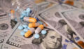 Pills and capsules in a bottle on US dollars bills