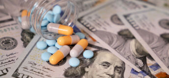 Pills and capsules in a bottle on US dollars bills