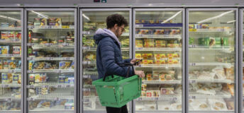 Photograph of a man shopping in a grocery store.