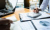 Ardian co-CEO Mark Benedetti details mispricing opportunities; Apollo Sports Capital invests in Yankee Global Enterprises; New Heritage backs PowerRail business audits using a calculator financial data investment fund at a workplace, wealth concept