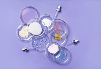 Cosmetic products, scrub, face serum and gel in many petri dishes on a pink background. Cosmetics laboratory research concept.