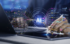 Image of a digital AI button hovering over a laptop, symbolizing the synthesis of data.