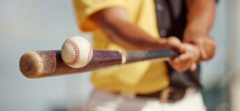 Baseball player hitting a baseball with a bat.