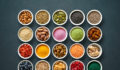 Various colorful superfoods as acai powder, turmeric, matcha green tea, spirulina, quinoa, pumpkin seeds, blueberry, dried goji berries, cape gooseberries, raw cocoa, hemp seeds and other in bowls on dark background